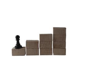 peças de xadrez em um bloco de madeira. conceito de objetivos de um funcionário que quer alcançar o maior sucesso foto