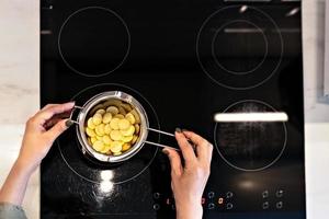 vista de cima da manteiga de cacau orgânica derretida em banho-maria para a preparação de cosméticos para cuidados com a pele do corpo. processo de cozimento. spa em casa. Pequenos negócios foto