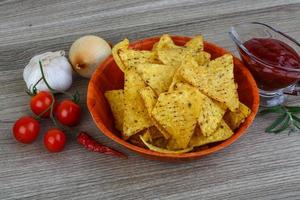 nachos em uma tigela no fundo de madeira foto