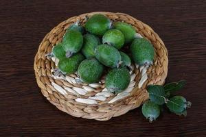 fruta feijoa na placa de madeira e fundo de madeira foto