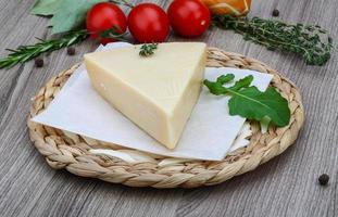 queijo parmesão na tábua de madeira e fundo de madeira foto