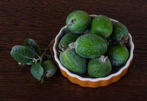 fruta feijoa em uma tigela com fundo de madeira foto