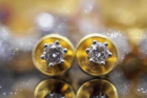 brincos de diamante de joias de ouro de luxo com reflexo no fundo preto foto