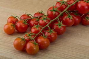 tomate cereja em fundo de madeira foto