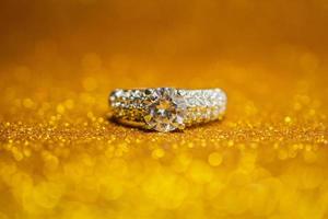 anel de diamante de casamento de joias em fundo claro de bokeh glitter dourado foto