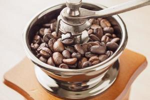 moedor de café manual vintage com grãos de café torrados foto
