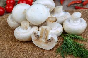 champignons na tábua de madeira e fundo de madeira foto