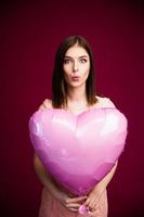 mulher segurando um balão em forma de coração foto