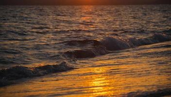 belo pôr do sol no mar à noite foto