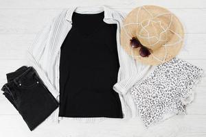 camiseta preta closeup mock up flat lay no fundo branco de madeira. vista superior e copie o espaço. t-shirt de maquete e verão. modelo de camisa em branco. foto