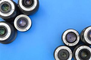 várias lentes fotográficas estão em um fundo azul brilhante. espaço para texto foto