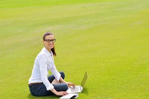 mulher com laptop no parque foto