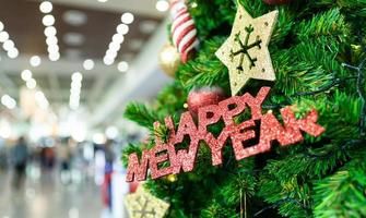 árvore de natal com decoração, rótulo de feliz ano novo e presente. feliz Natal e Feliz Ano Novo. foto