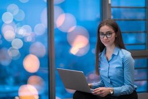 uma jovem sentada em um espaço moderno enquanto trabalhava em um projeto em um laptop. foco seletivo foto