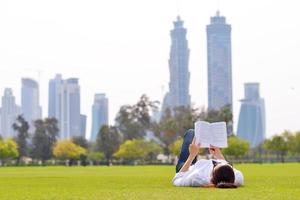 jovem lendo um livro no parque foto