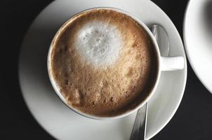 xícara de café de cerâmica branca cheia de um cappuccino foto