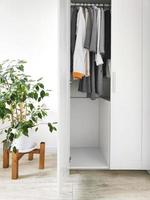 guarda-roupa com roupas básicas no interior do quarto scandi. foto