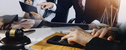 justiça e direito concept.male juiz em um tribunal na mesa de madeira e conselheiro ou advogado masculino trabalhando no escritório. direito jurídico, aconselhamento e conceito de justiça. foto