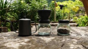 o conjunto de café de gotejamento inclui grãos de café, chaleira de gotejamento e um moedor de café. coloque na mesa de madeira. foto