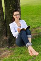 jovem lendo um livro no parque foto