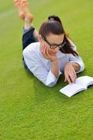 jovem lendo um livro no parque foto