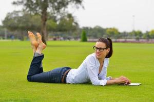 mulher jovem e bonita com tablet no parque foto