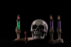 crânio humano de halloween em uma velha mesa de madeira sobre fundo preto. forma de osso do crânio para a cabeça da morte no festival de halloween que mostra horror mal vela fumaça medo e assustador, copie o espaço foto