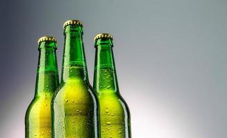 close de três gargalos de garrafas de cerveja verdes foto