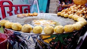 homem fazendo aloo tikki, costeletas de batata frita, comida de rua da índia barraca de comida. foto