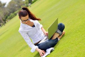 mulher com laptop no parque foto