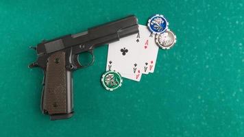 um tiro superior de uma arma ao lado de algumas cartas de baralho e dados em um tabuleiro de pôquer. foto