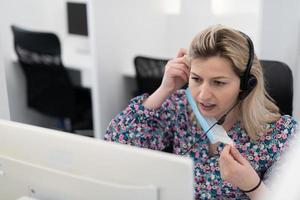 operador de call center com máscara médica foto