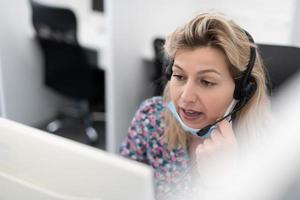 operador de call center com máscara médica foto