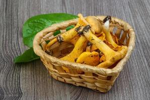 chanterelle em uma cesta em fundo de madeira foto