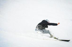 esquiador iniciante sem luvas e capacete cair na neve com força. roupas ruins no conceito de estância de esqui. preparação de férias de férias de inverno foto