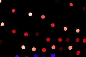 efeitos de luz bokeh abstratos de desfocagem vermelha na textura de fundo preto à noite foto