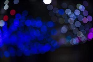 efeitos de luz bokeh abstratos de desfocagem azul na textura de fundo preto à noite foto