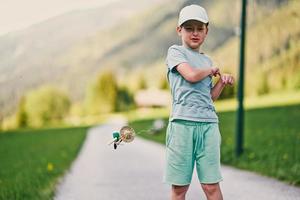 menino com brinquedo de madeira jogar em prado alpino em untertauern, áustria. foto