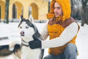 homem andando com cachorro, inverno com neve
