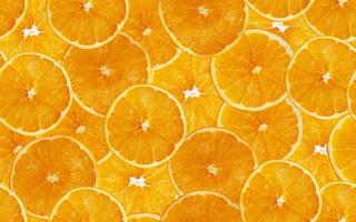 fundo sem emenda de fatias de laranja. corte frutas cítricas amarelas. foto