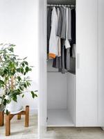 guarda-roupa com roupas básicas no interior do quarto scandi. foto