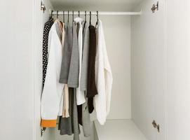 guarda-roupa com roupas básicas no interior do quarto scandi. foto