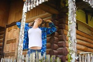 mulher atraente na casa de madeira, ambiente descontraído de verão
