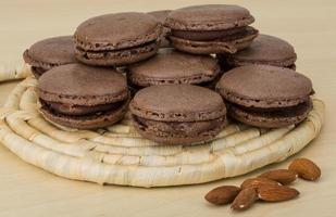 macaroons de chocolate na placa de madeira e fundo de madeira foto