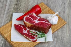 chuck steak na tábua de madeira e fundo de madeira foto