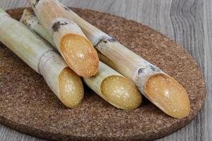 palitos de açúcar na placa de madeira e fundo de madeira foto