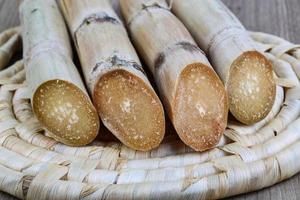 palitos de açúcar na placa de madeira e fundo de madeira foto