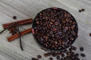grãos de café em uma tigela com fundo de madeira foto