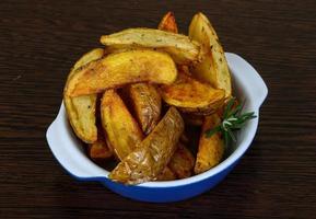 batata assada em uma tigela com fundo de madeira foto