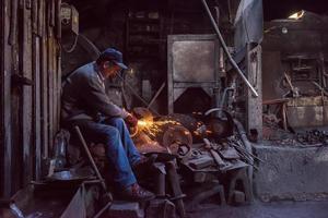 o ferreiro polindo produtos de metal foto